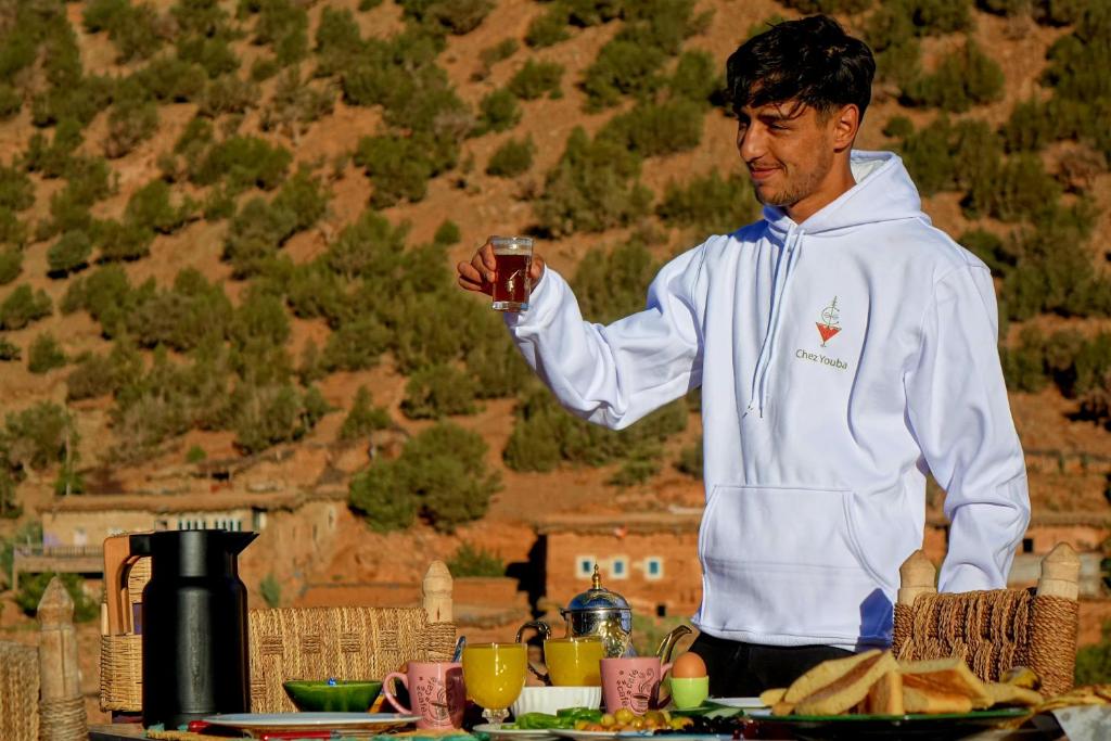 a man is holding a glass of wine at Chez youba in Azilal