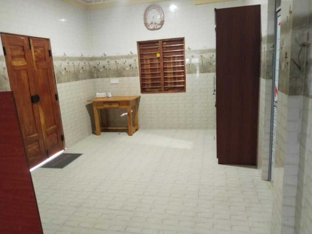 a bathroom with a sink and a desk in a room at Thamilarasan inn in Jaffna