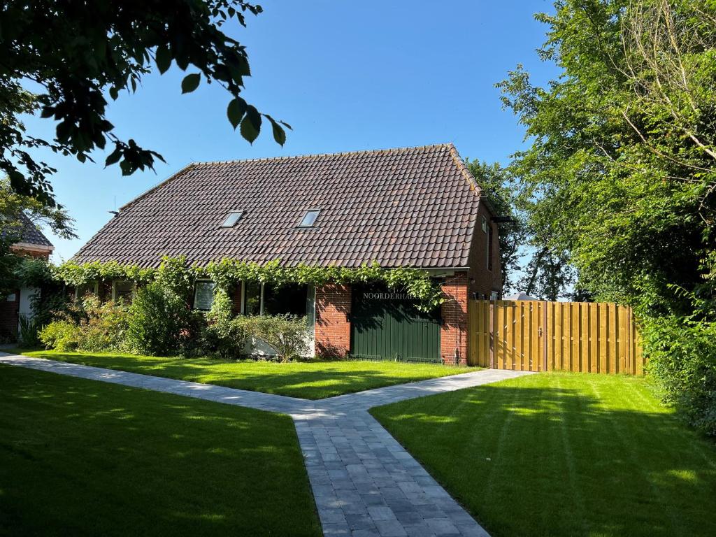 a house with a fence and a grass yard at Noorderhaecks in 't Horntje