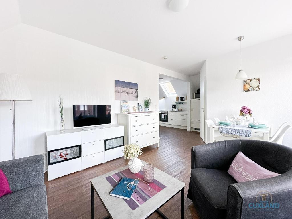 a living room with a couch and a tv at Hus Krüüzpadd boben in Cuxhaven