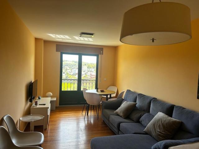 a living room with a blue couch and a table at Piso moderno in Sarria
