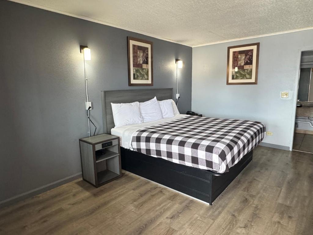 a bedroom with a bed with a black and white checkered blanket at Travel Inn in Broadview