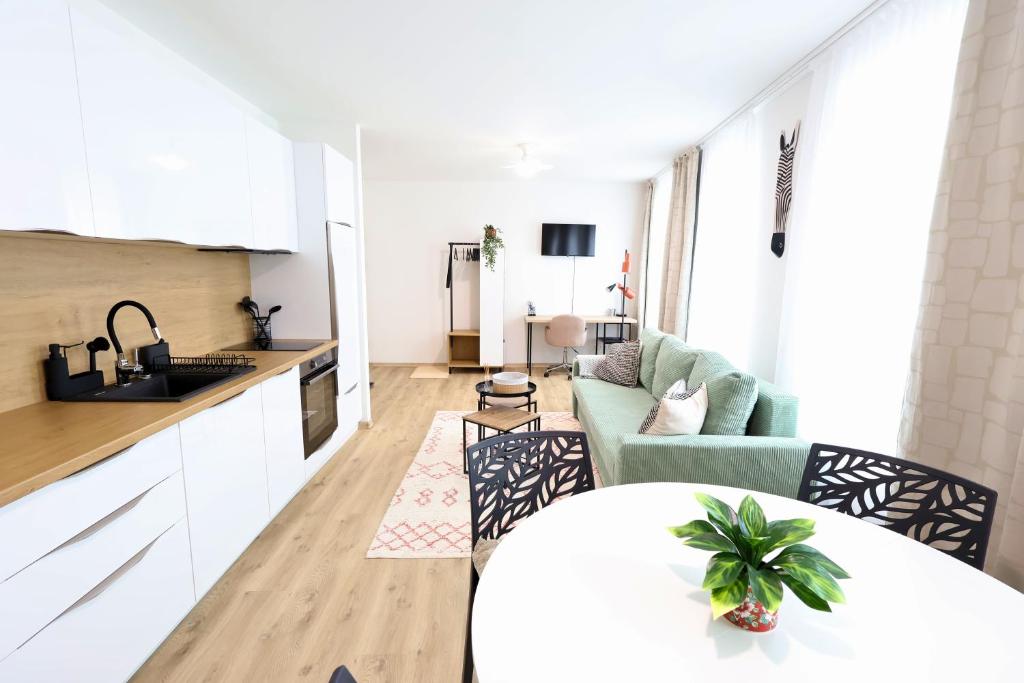 a kitchen and living room with a table and a couch at St Antoni Suite 4 in Eisenstadt