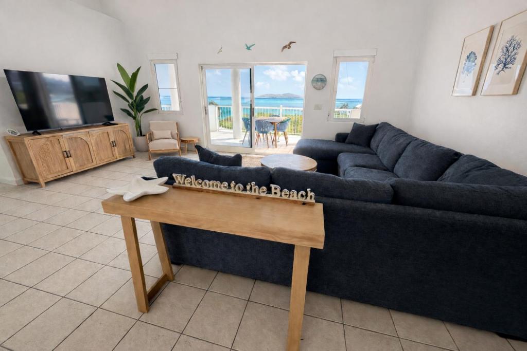 a living room with a blue couch and a table at The View at Green Cay - Full AC - Walk to the Beach in Christiansted