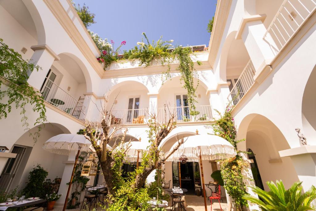 a courtyard of a building with tables and umbrellas at Casa Amor Olhão in Olhão