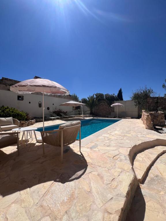 a patio with a table and an umbrella and a pool at Mirramor in Campo de Mirra