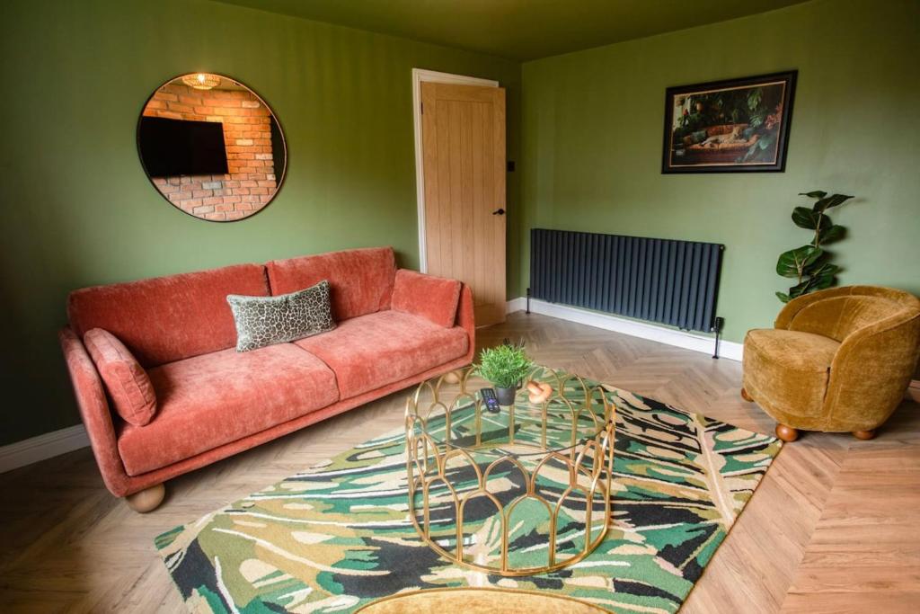 a living room with a red couch and a glass table at Unique 3 Bed Home, Stewarton in Stewarton