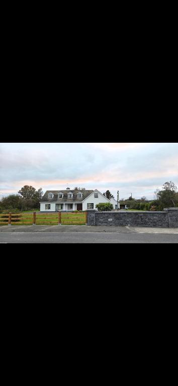 a large white house on the side of a road at Crossriver B&B in Oughterard