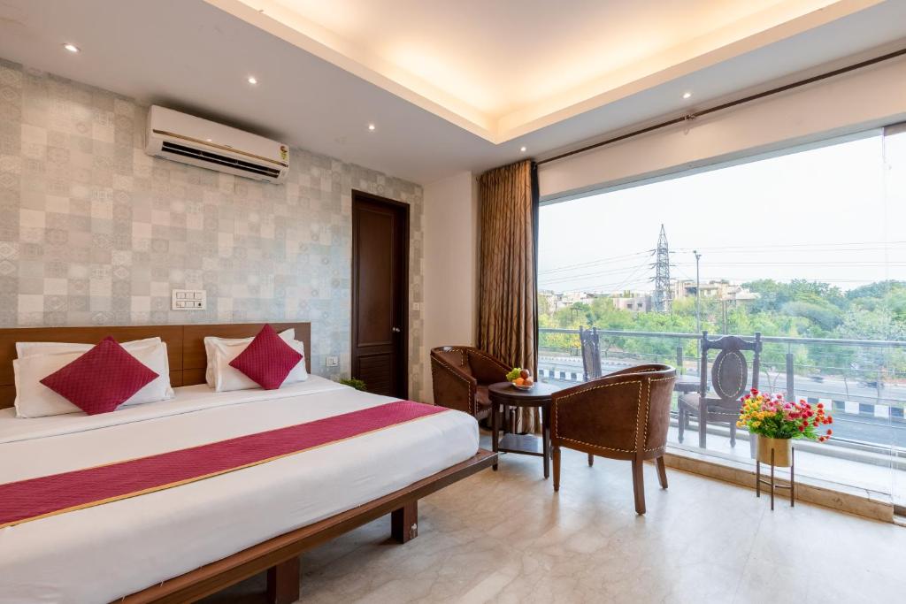 a hotel room with a bed and a balcony at Hotel The Imperio, Near Apollo Hospital, JASOLA in New Delhi