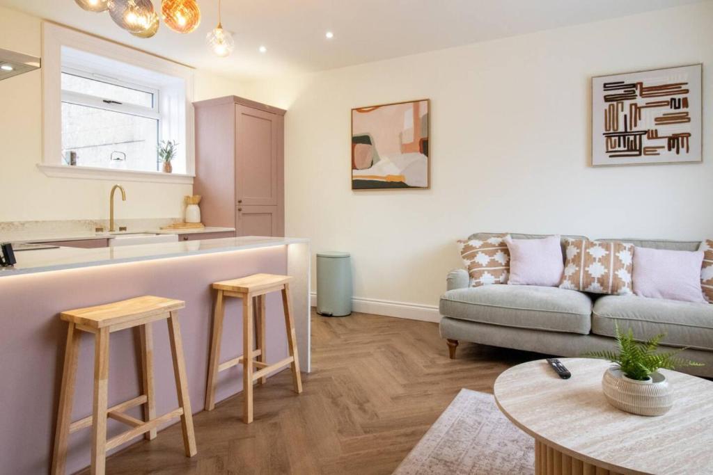a kitchen and living room with a couch and a table at Unique 1 Bed Apartment, Auchterarder in Auchterarder