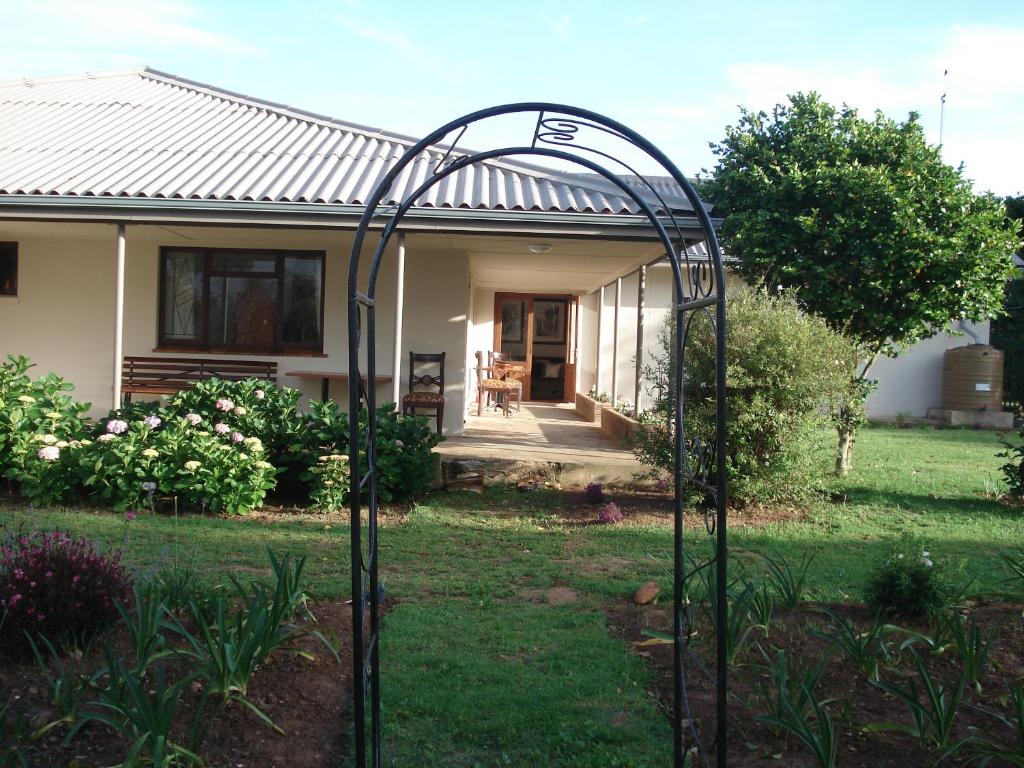 
a garden area with a fence and a building at Lalani B&B/Self catering Cottages in Riversdale
