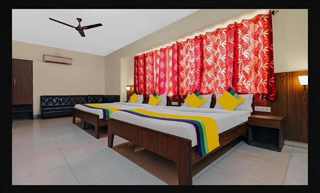 a bedroom with two beds with red curtains at Hotel Starwood Near Airport Road Sector 78 Mohali Chandigarh in Mohali