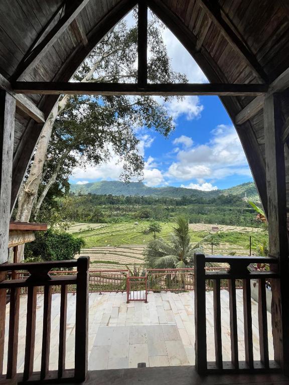 an arched window looking out at a view of a field at Rice Field and Mountain View House in Karangasem