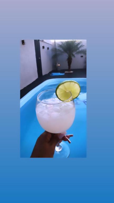 a cocktail in front of a swimming pool at Casa com piscina in Londrina