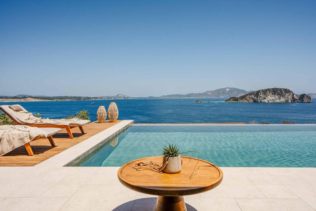 a pool with a table and chairs next to the water at Aurora Thesan in Marathias