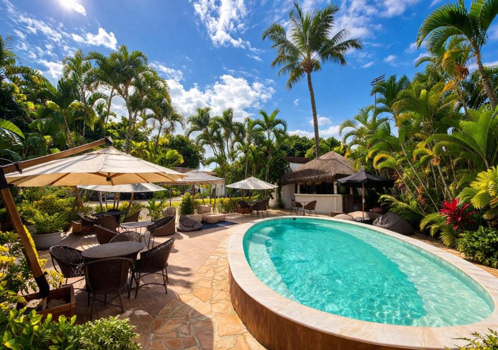 a pool at a resort with tables and chairs at Pousada Montemar in Ilhabela