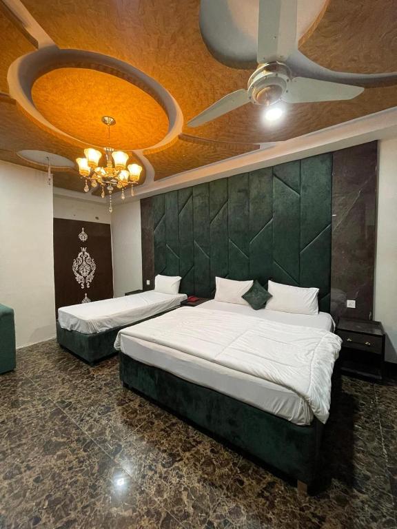 a bedroom with two beds and a green wall at Arizona 2 in Islamabad