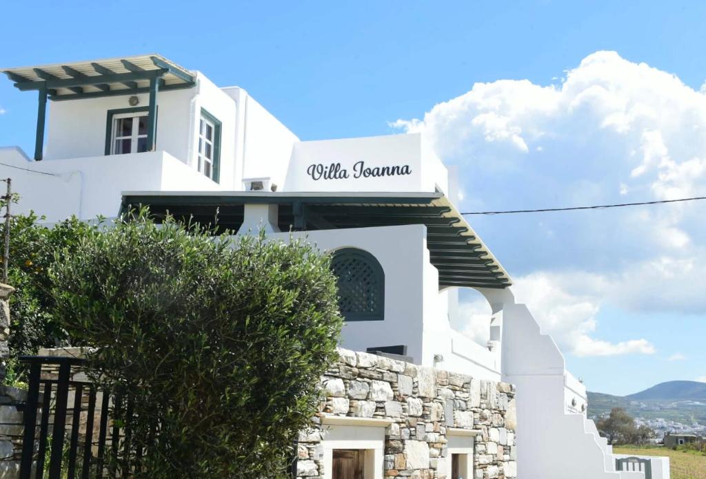 a white building with a sign on it at Villa Ioanna in Agkidia