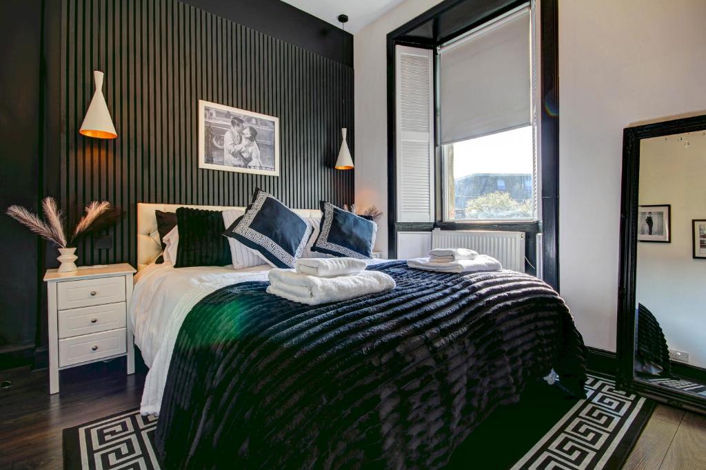 a bedroom with a large bed and a window at Tiffanys Boutique - Coorie Doon Stays in Prestwick