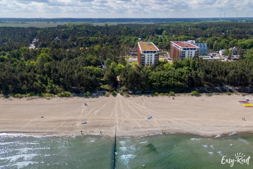 an aerial view of a beach with people in the water at Prestige 113 - tuż przy plaży, z widokiem na morze, parkingiem i WiFi w cenie pobytu - Easy-Rent Apartments in Pobierowo