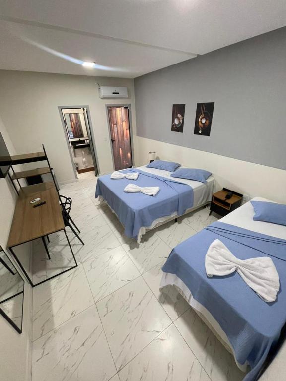 a hotel room with two beds and a piano at Hotel Acqua Park in Capim Grosso
