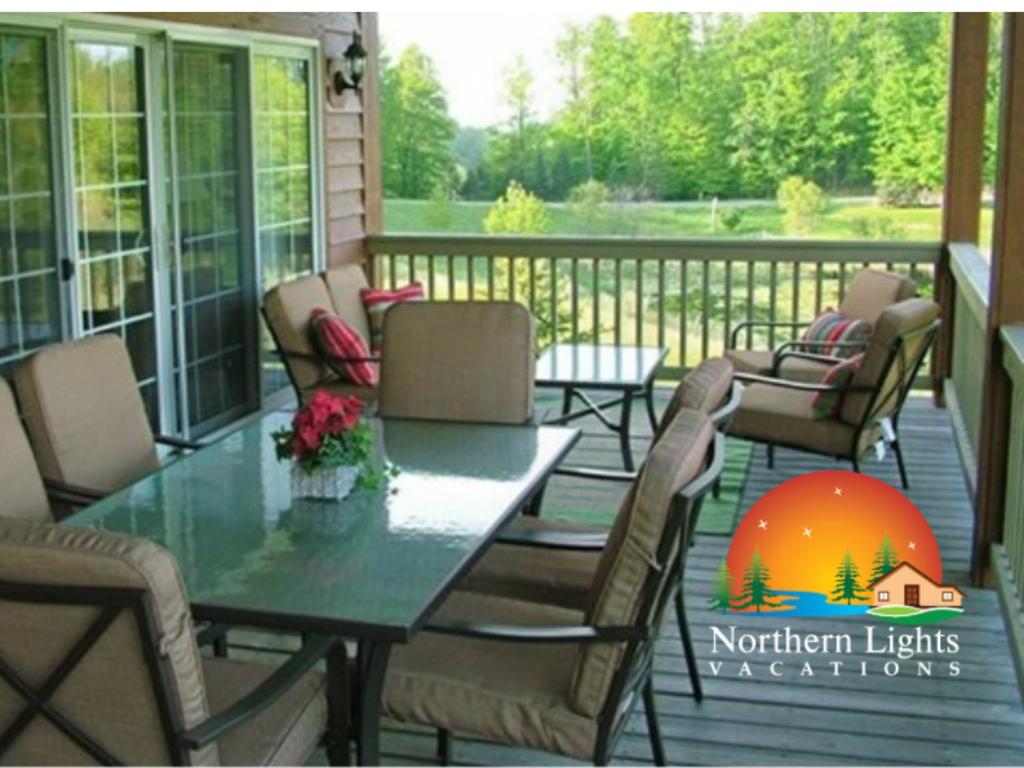 a screened in porch with a table and chairs at Sunny Days at Shanty Creek in Bellaire