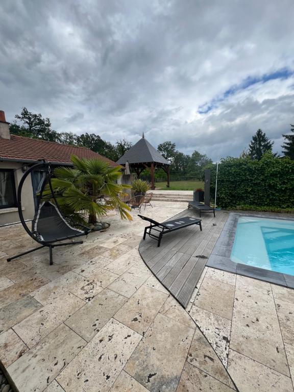 a backyard with a swimming pool and a table and chairs at Le Val Cosy in Montlivault