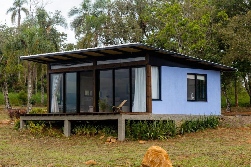 a tiny house with a large window on a field at Morada do Valle Chalés in Timbe do Sul