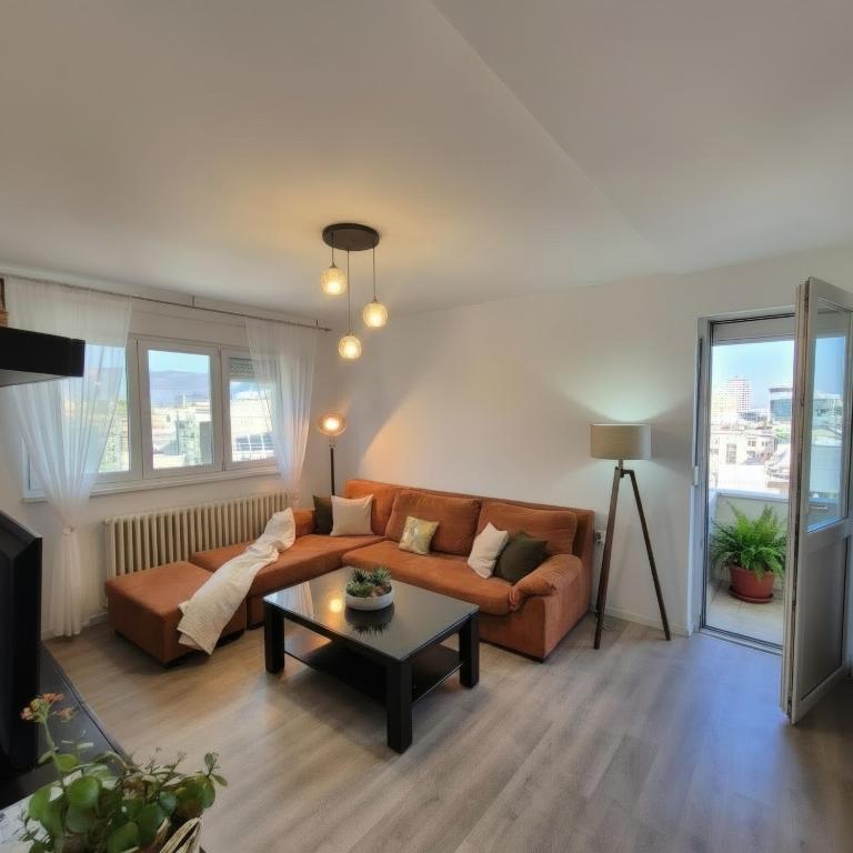 a living room with a couch and a table at Above the City, walk everywhere - 2BR, 2 Baths in Skopje