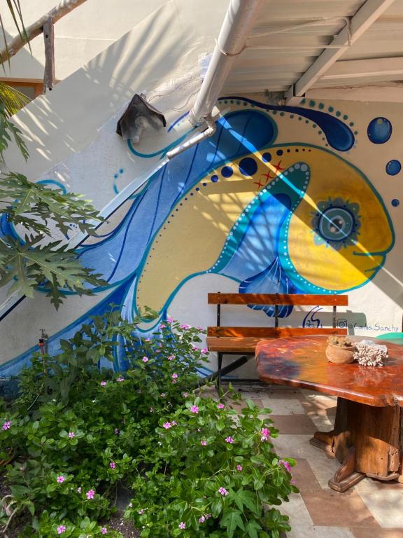 a mural of a fish on a wall with a bench at El Barquero in Puerto Baquerizo Moreno
