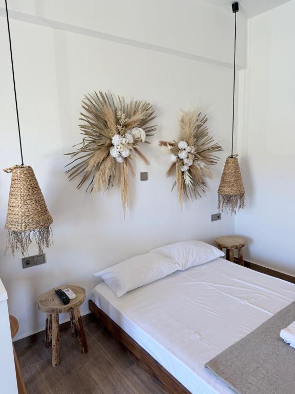 a bedroom with a bed and two flowers on the wall at Kanal Vstay #2 in Kithnos