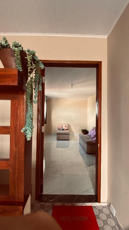 a hallway with a living room with a couch at Quarto Triplo in Areia