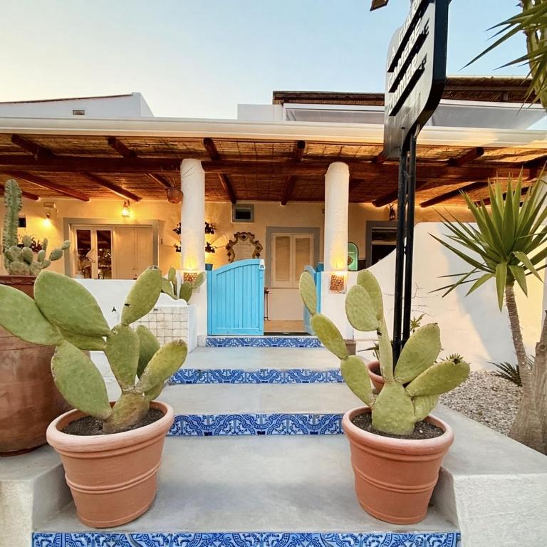 a house with three plants in front of it at La Giara in Vulcano
