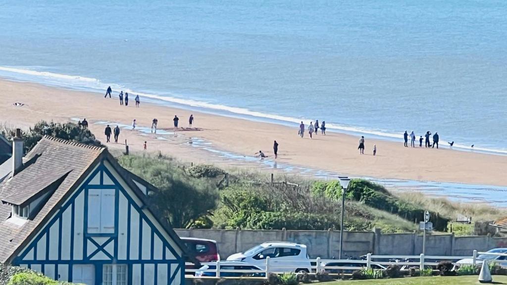 a group of people walking on a beach at Cabourg-Angle bleu in Cabourg