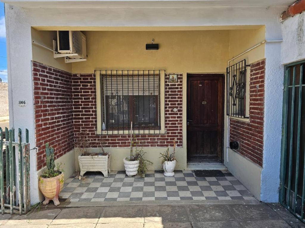 a front porch of a brick house with potted plants at Buena Vista Centro in Concordia