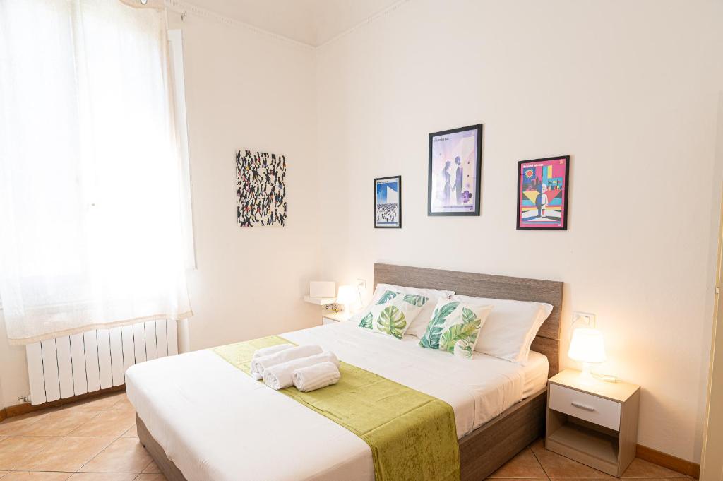 a white bedroom with a bed and a window at Titina Apartment Novoli Close to Center & Airport in Florence