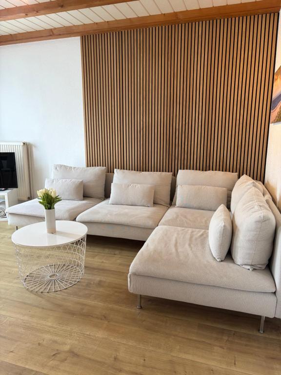a living room with two white couches and a table at Ferienhaus Mundan 2 in Burhave