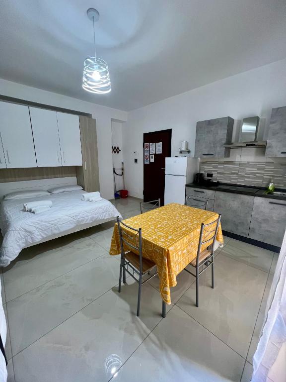 a kitchen with a table and a bed in a room at Affittacamere La bottega del barbiere in Scalea