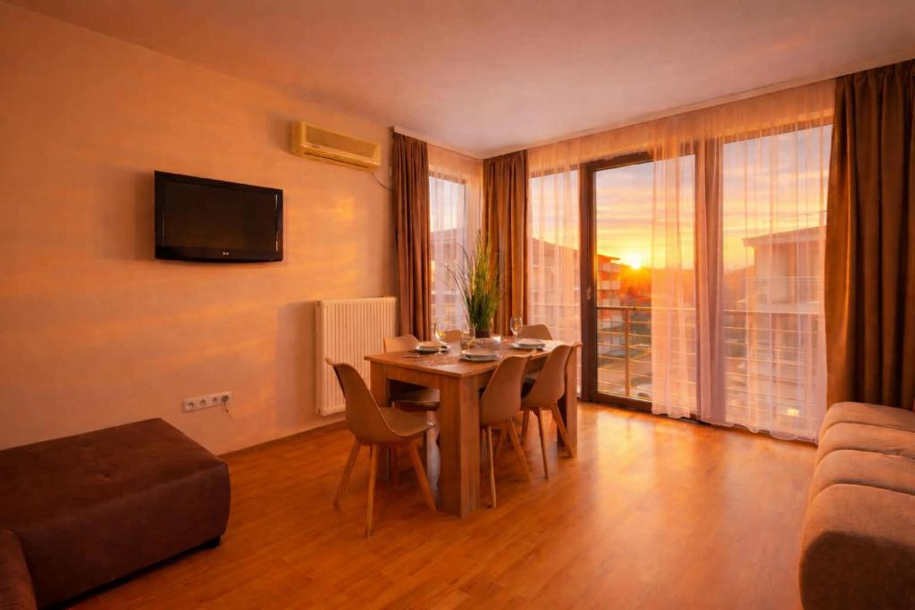 a living room with a table with chairs and a television at Fritz Holiday in Siófok