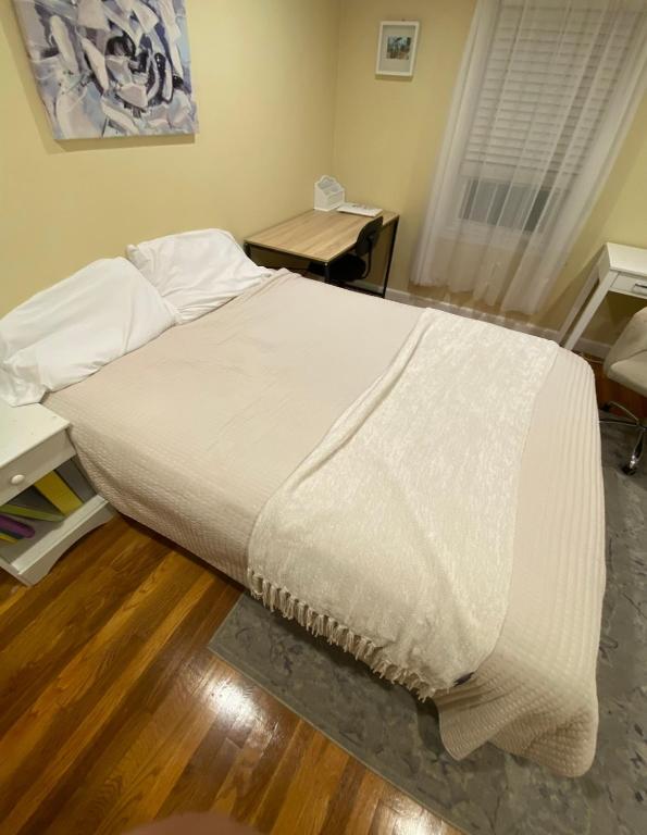 a bedroom with a large bed with white sheets at spacious room with great amenities in Boston