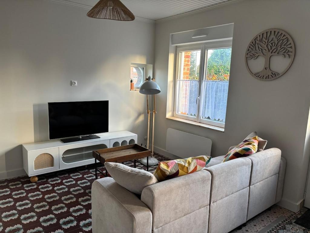 a living room with a couch and a flat screen tv at Maison rénovée - 2 chambres - 4 pers - L'Abeel Escapade in Bailleul