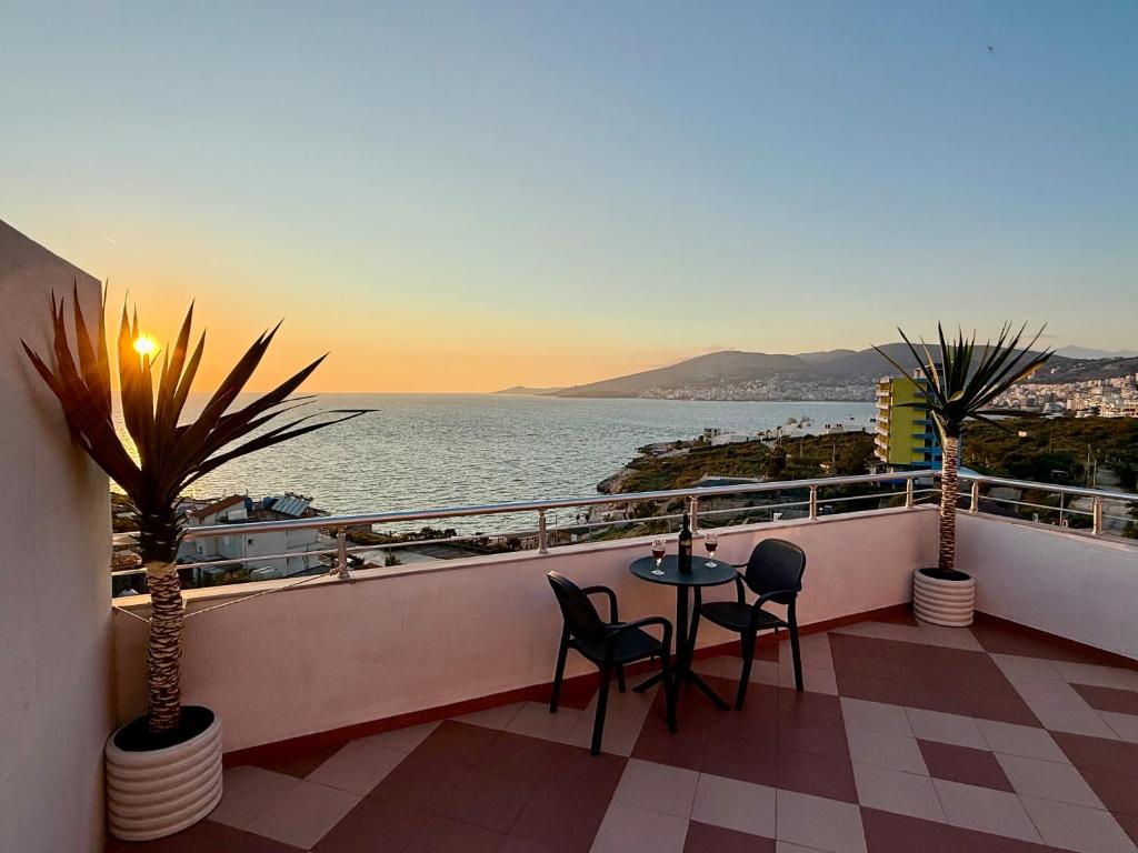 a balcony with a table and chairs and the ocean at Apartments Vila Ardi in Sarandë
