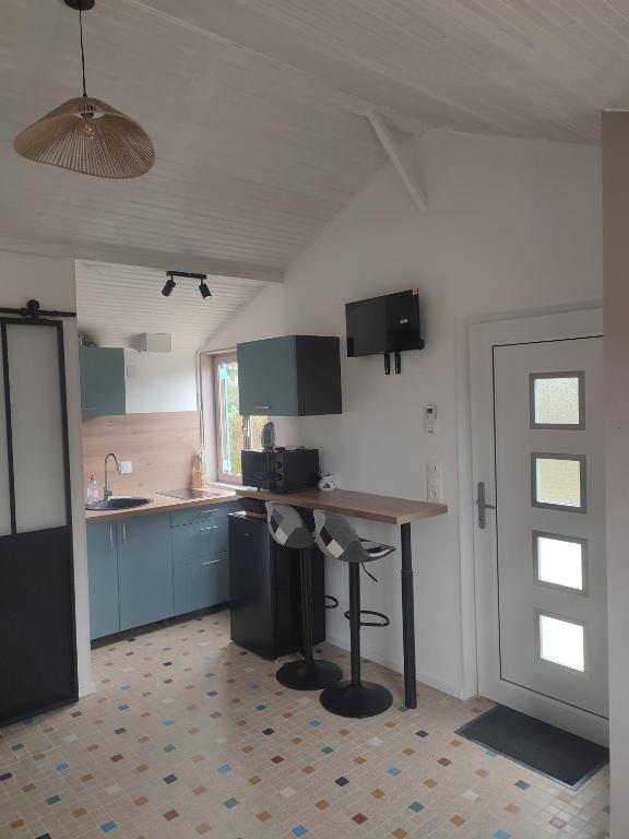 a kitchen with blue cabinets and a wooden table at Le 13 au vert in Montigny-les-Monts