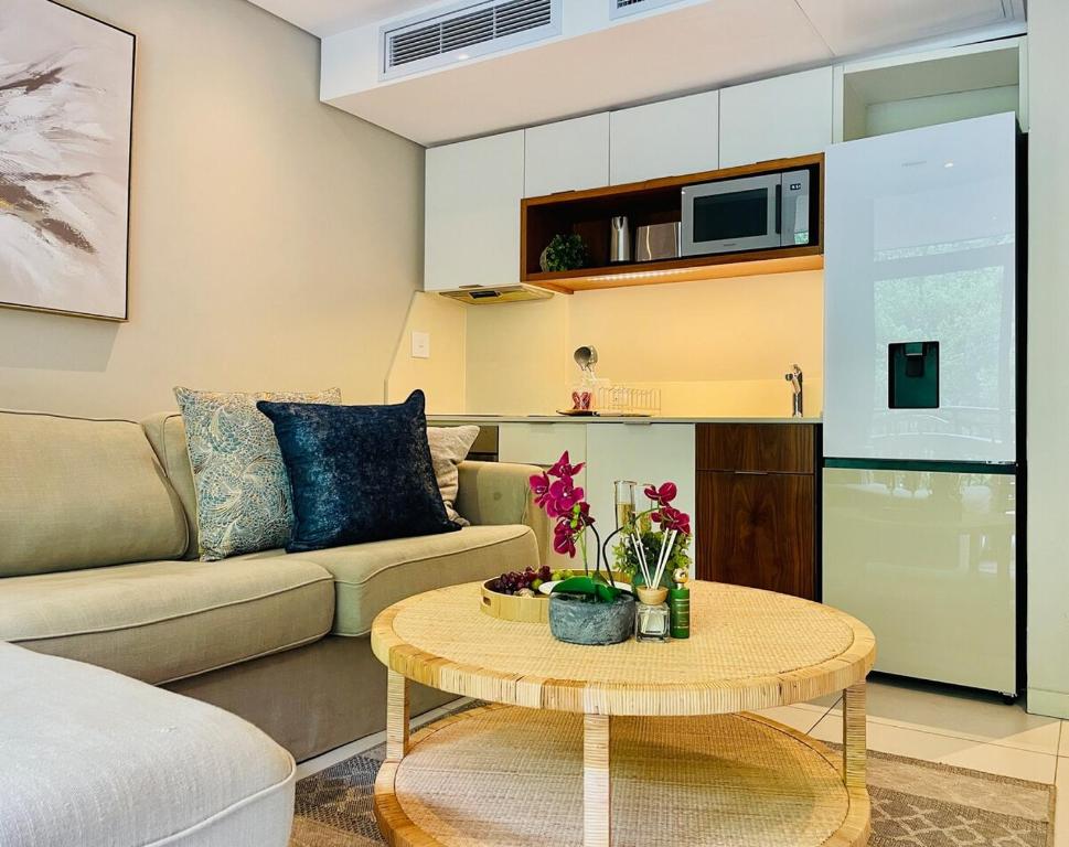 a living room with a couch and a table at 320 Zimbali Suites in Ballito