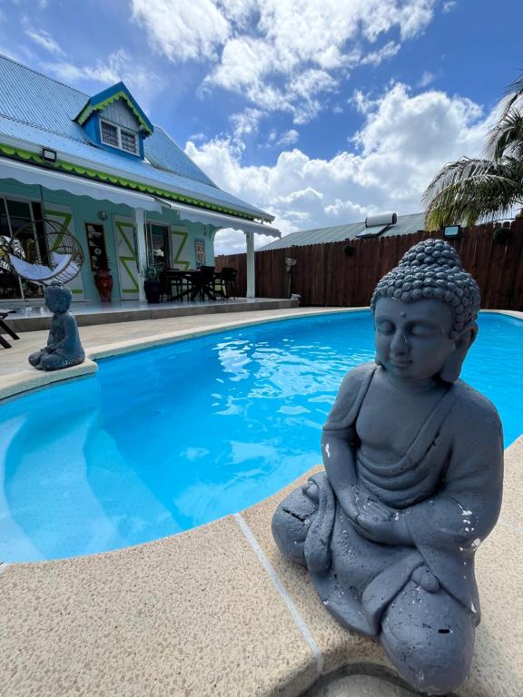 a statue sitting next to a swimming pool at Villa Caillou in Lamentin