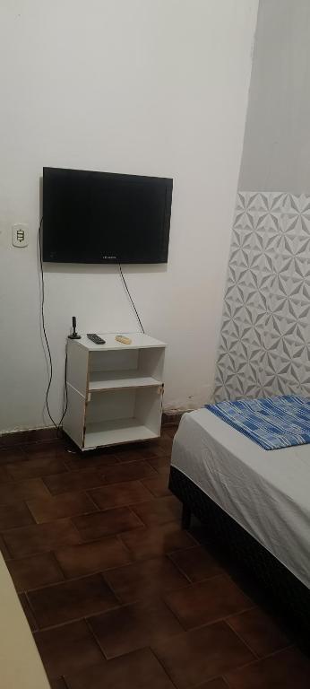 a room with a bed and a tv on a wall at Pousada Popular in Barreiras