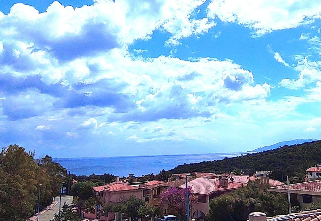 a view of a town with the ocean and clouds at Domus de mare in Cala Gonone