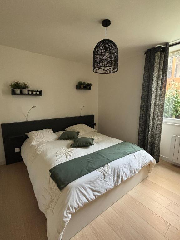 a bedroom with a bed in a room with a window at Centre ville - Le Creusot in Le Creusot