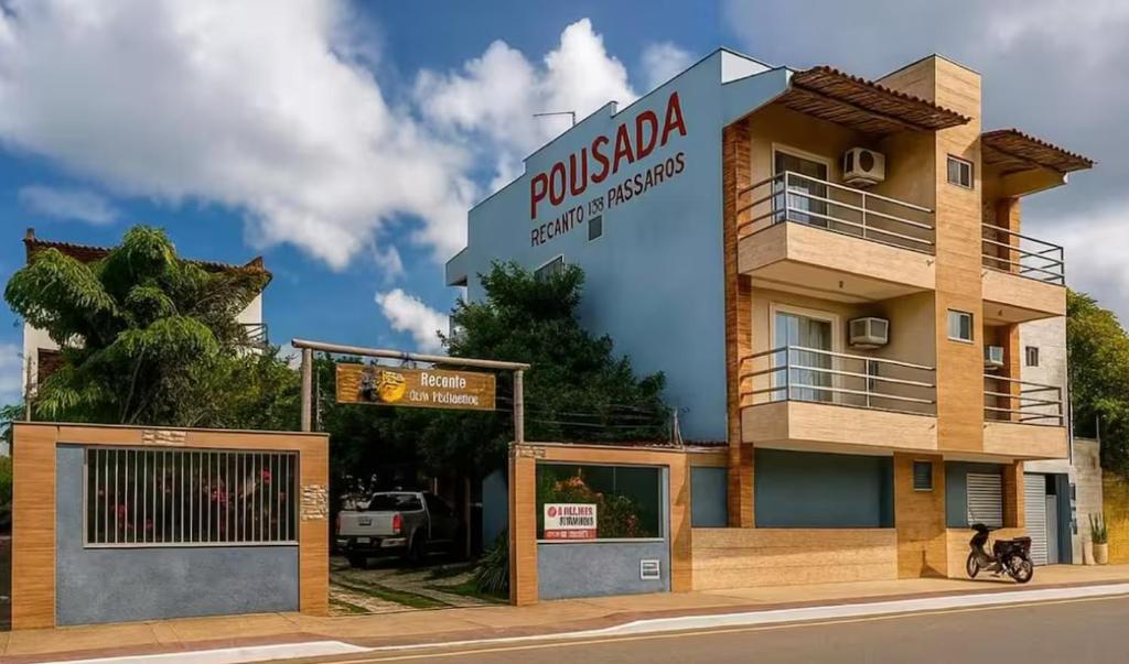 a building with a sign on the side of it at Pousada Recanto dos Pássaros in Linhares