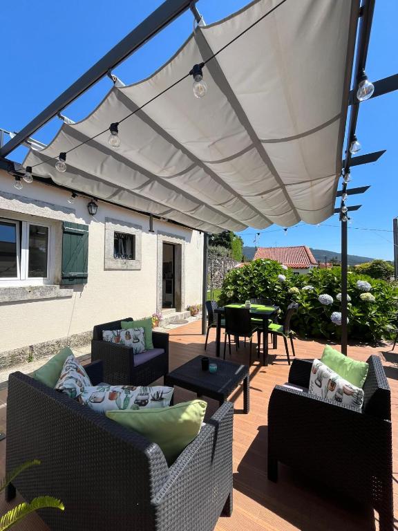 a patio with a white umbrella on a deck at Beach House Largo da Agrela in Viana do Castelo